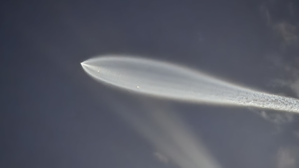 Falcon-9 exhaust trail lit by sunlight